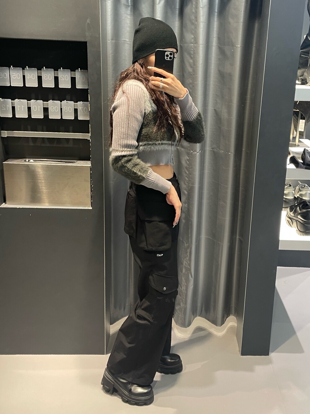 グレー系のニット/セーター、ブラック系のその他パンツ、ブラック系のブーツを着用したレディースの冬コーディネートの2枚目の写真