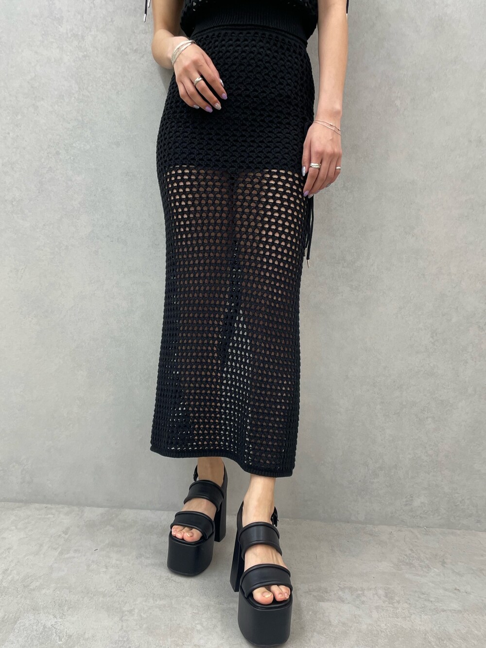 ホワイト系のキャミソール、ブラック系のタンクトップ、ブラック系のスカートを着用したレディースの春コーディネートの7枚目の写真