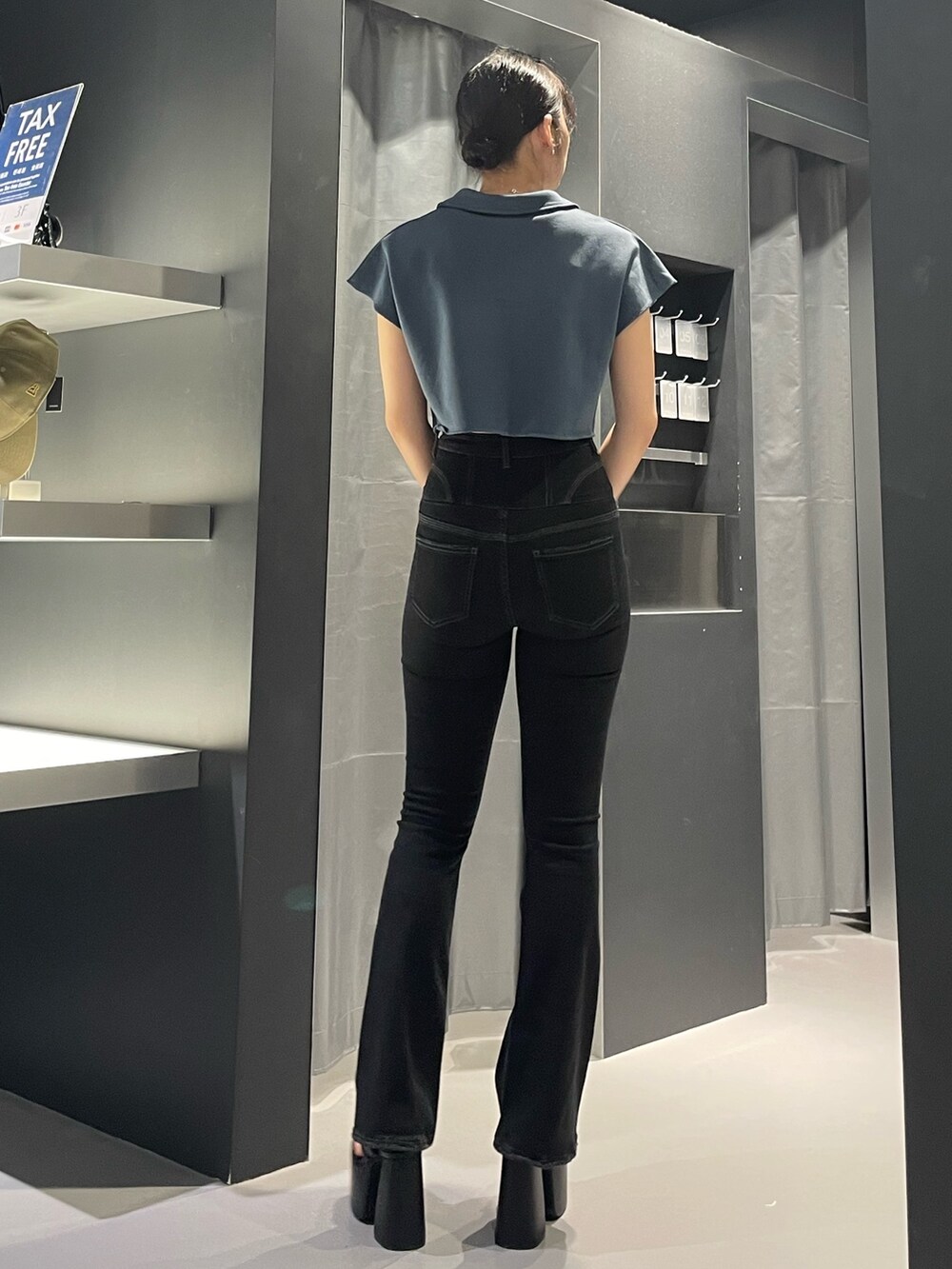 ブラック系のデニムパンツ、ブラック系のサンダル、ブルー系のTシャツ/カットソーを着用したレディースの夏コーディネートの3枚目の写真