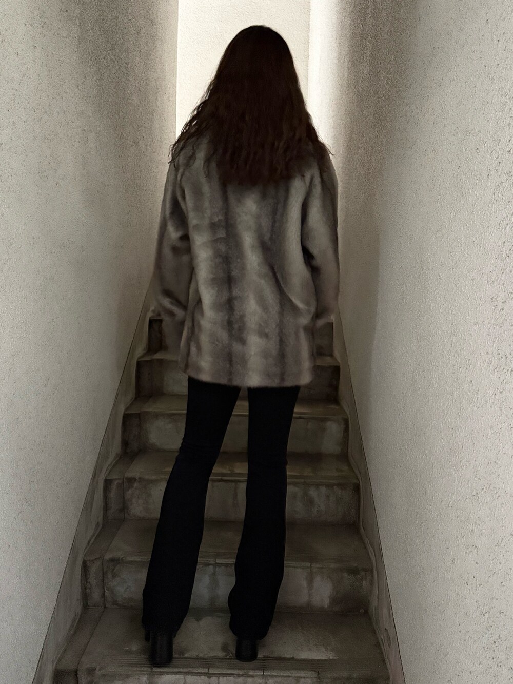 グレー系のその他アウター、ブラック系のデニムパンツ、ブラック系のブーツを着用したレディースの秋コーディネートの3枚目の写真