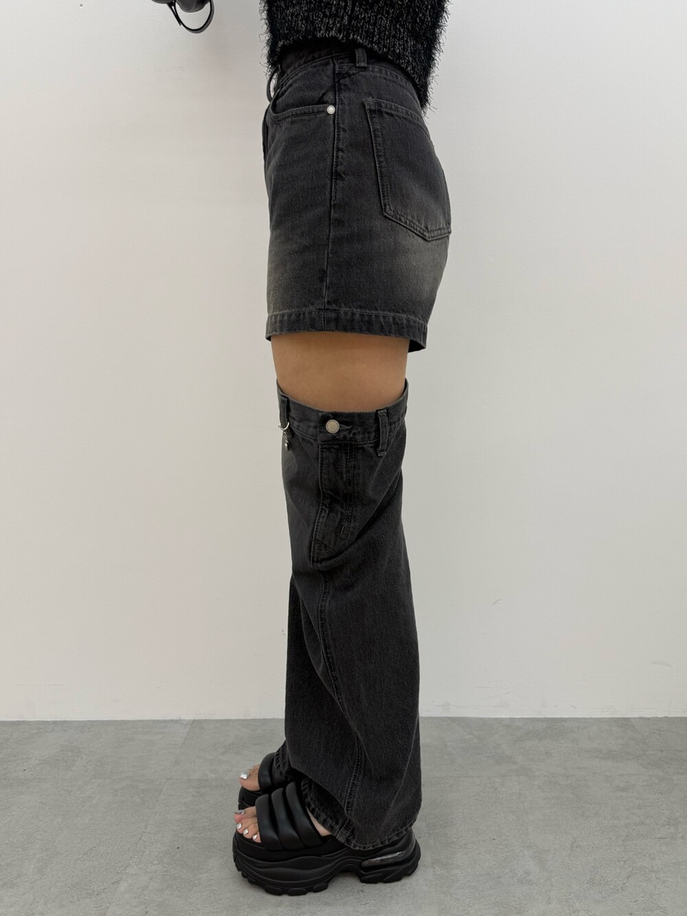 ブラック系のニット/セーター、ブラック系のデニムパンツ、ブラック系のハンドバッグを着用したレディースの夏コーディネートの8枚目の写真