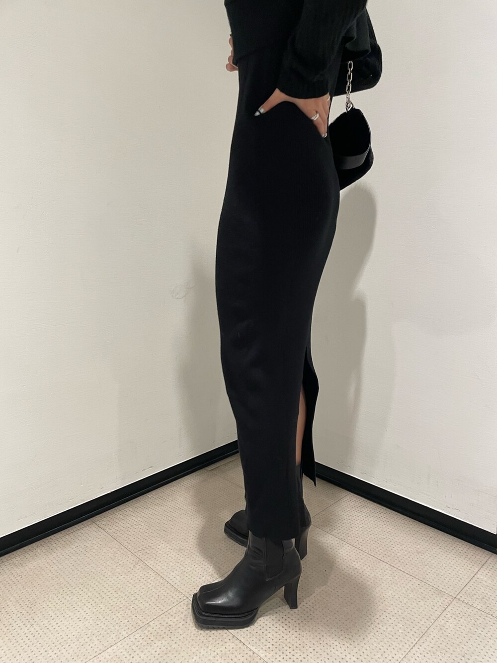 ブラック系のワンピース、ブラック系のハンドバッグ、ブラック系のブーツを着用したレディースの秋コーディネートの6枚目の写真