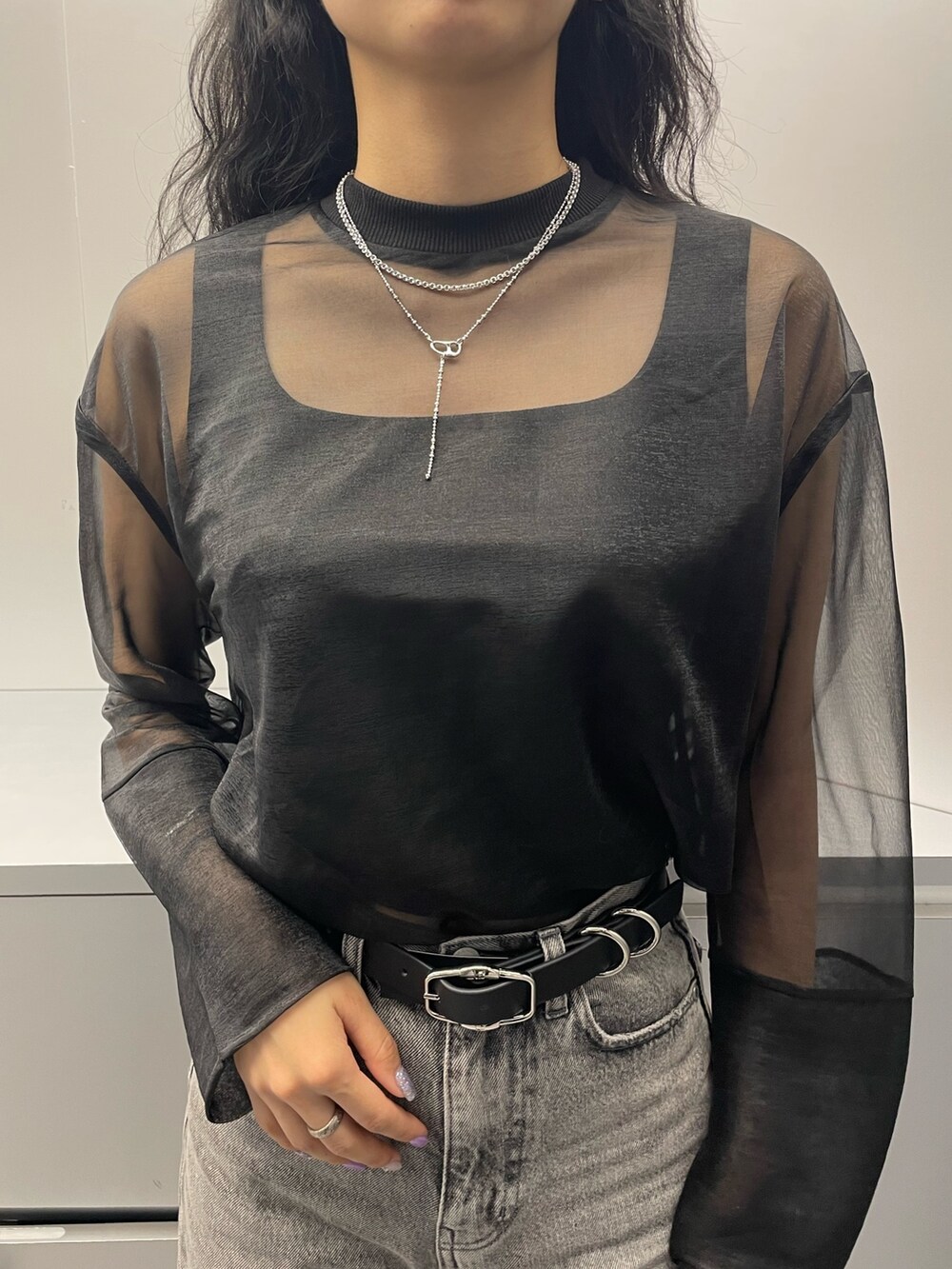 ブラック系のタンクトップ、ブラック系のTシャツ/カットソー、グレー系のデニムパンツを着用したレディースの春コーディネートの4枚目の写真