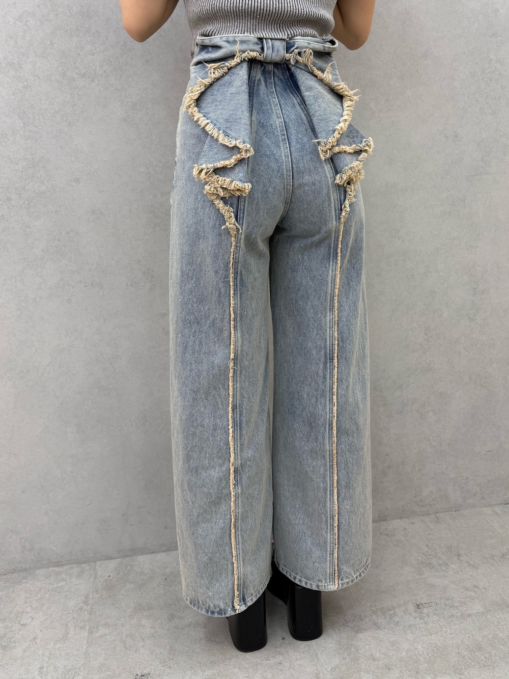 グレー系のニット/セーター、ブルー系のデニムパンツ、ブラック系のサンダルを着用したレディースの春コーディネートの6枚目の写真