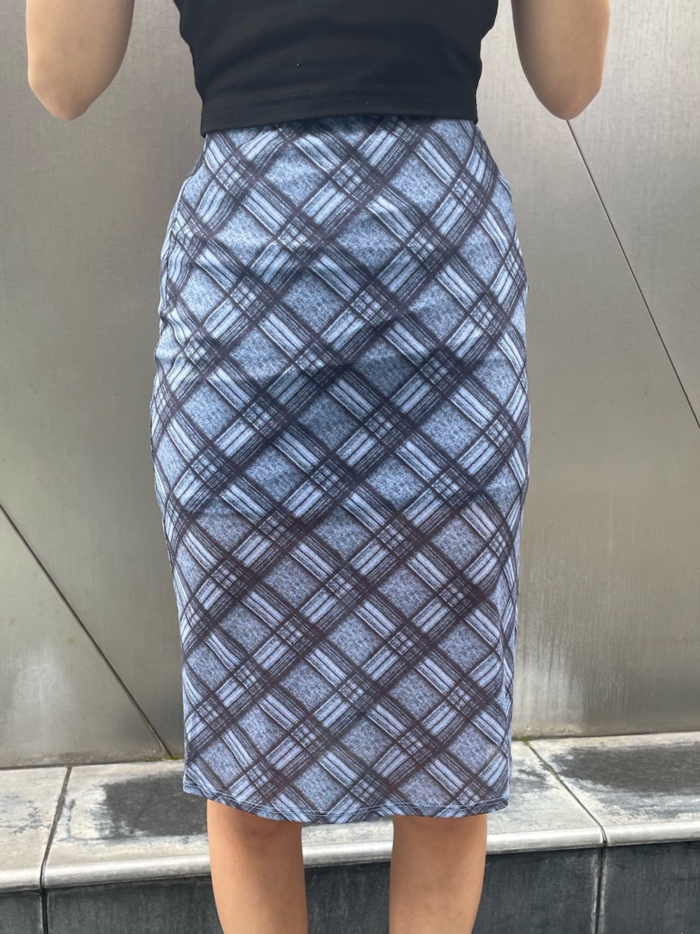 ブラック系のTシャツ/カットソー、ブルー系のスカート、ブラック系のサンダルを着用したレディースの夏コーディネートの6枚目の写真