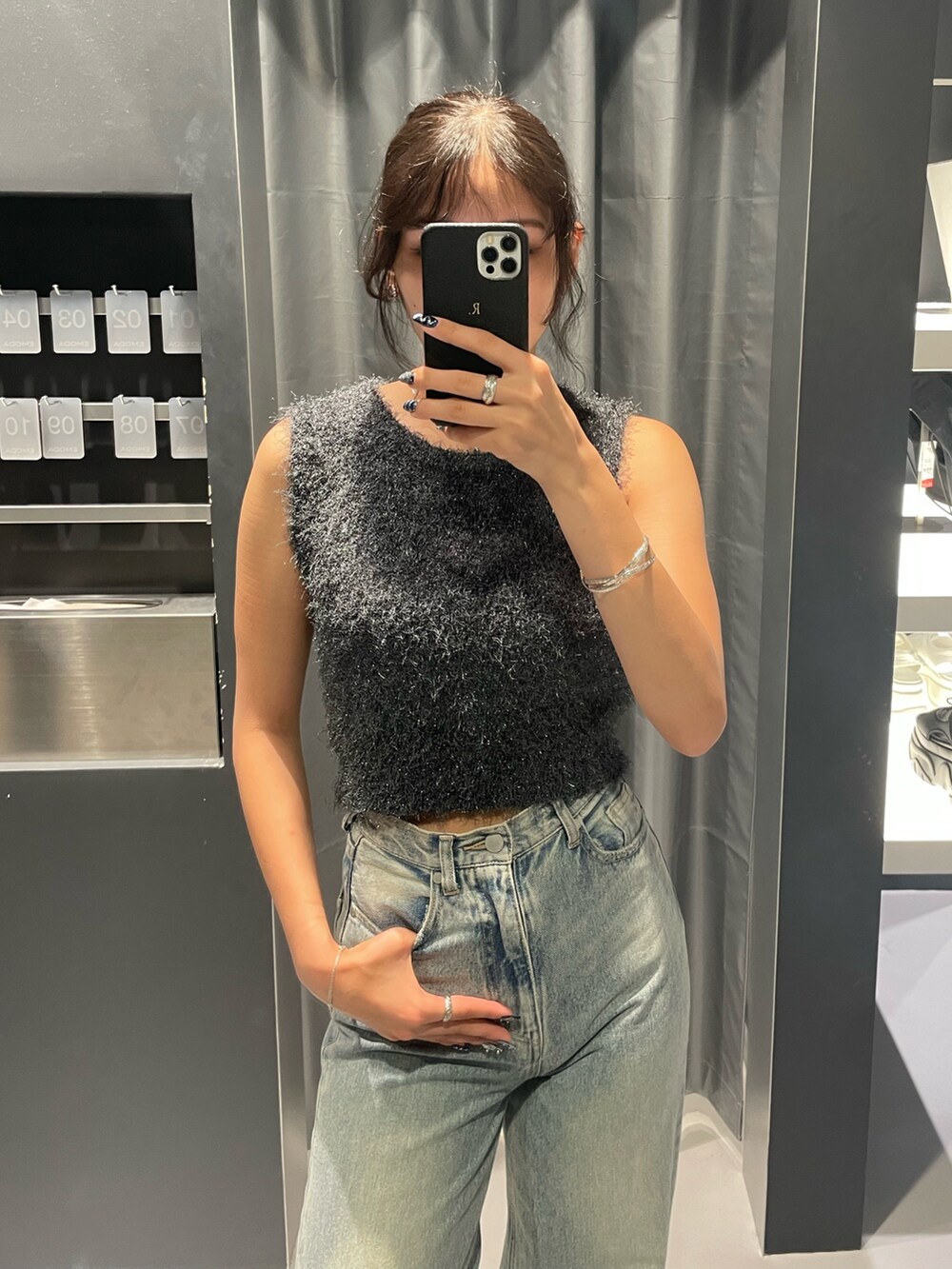 グレー系のタンクトップ、ブルー系のデニムパンツ、ブラック系のサンダルを着用したレディースの夏コーディネートの4枚目の写真