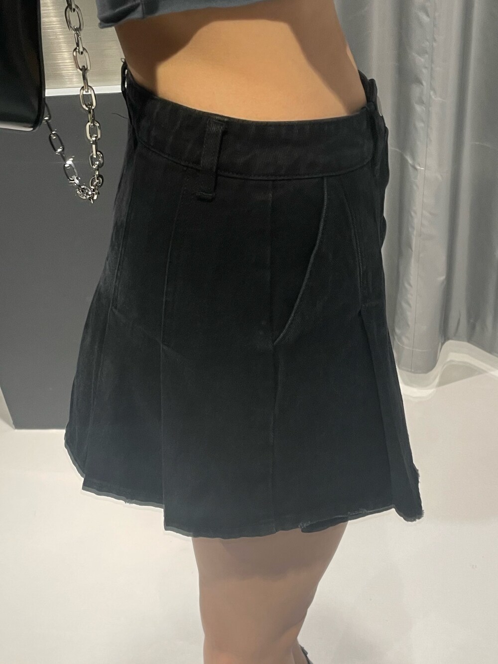 ホワイト系のTシャツ/カットソー、ブラック系のデニムスカート、ブラック系のショルダーバッグを着用したレディースの春コーディネートの8枚目の写真