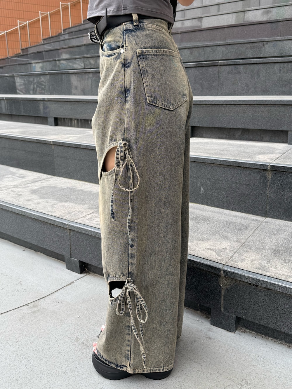 グレー系のTシャツ/カットソー、ブルー系のデニムパンツ、ブラック系のショルダーバッグを着用したレディースの春コーディネートの8枚目の写真