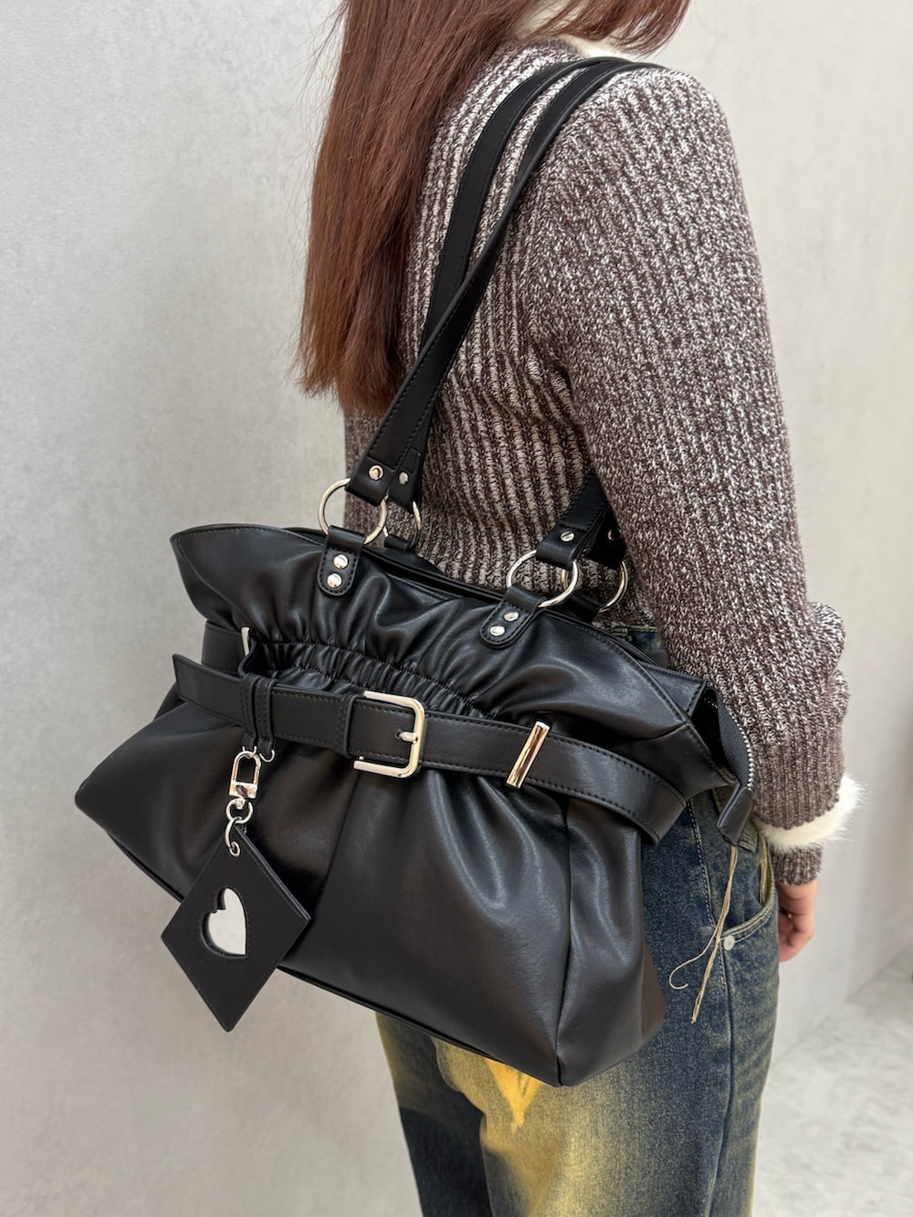 ブラウン系のニット/セーター、ブルー系のデニムパンツ、ブラック系のトートバッグを着用したレディースの冬コーディネートの5枚目の写真