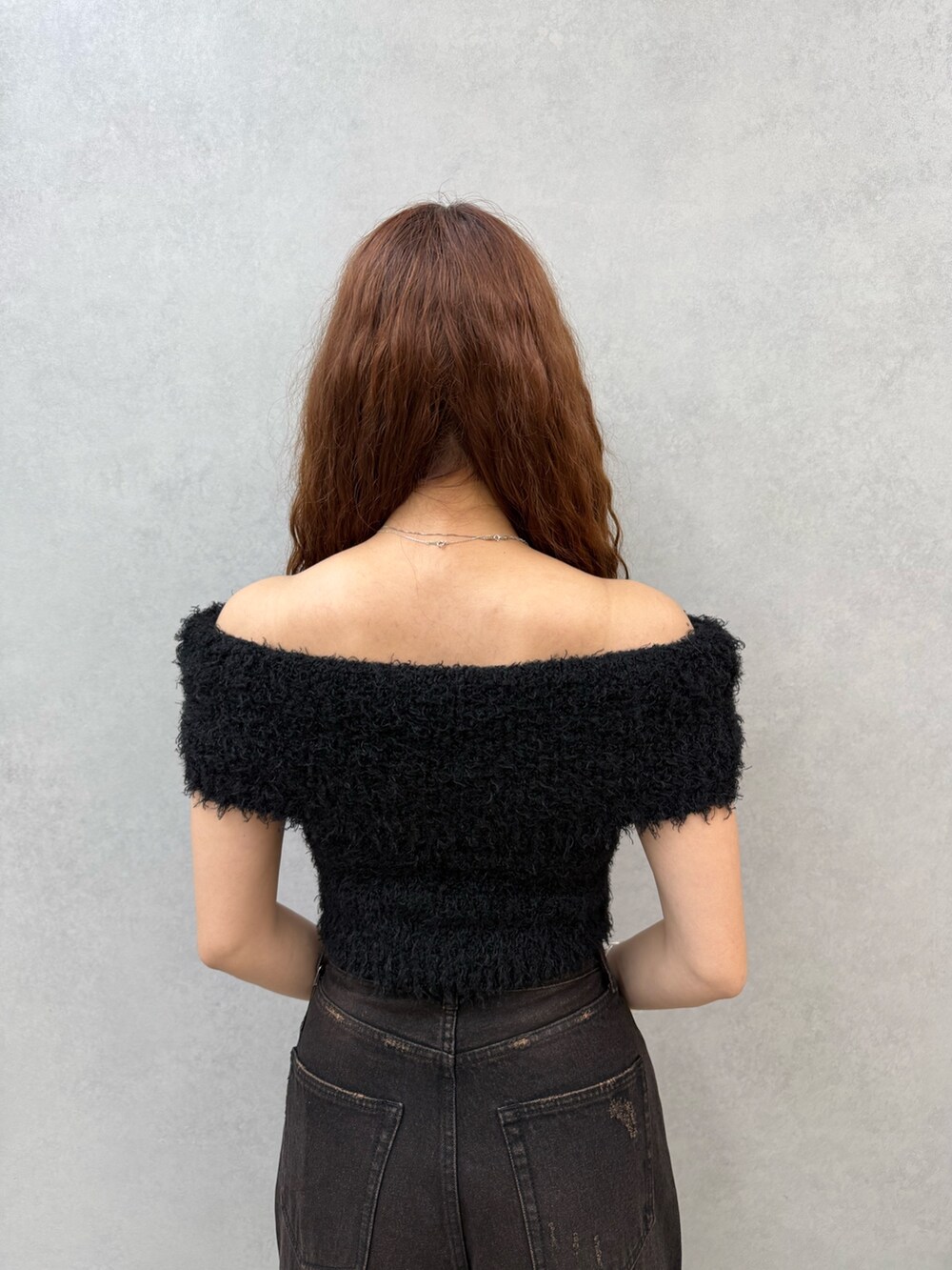 ブラック系のニット/セーター、ブラック系のデニムパンツ、ブラウン系のサンダルを着用したレディースの夏コーディネートの6枚目の写真