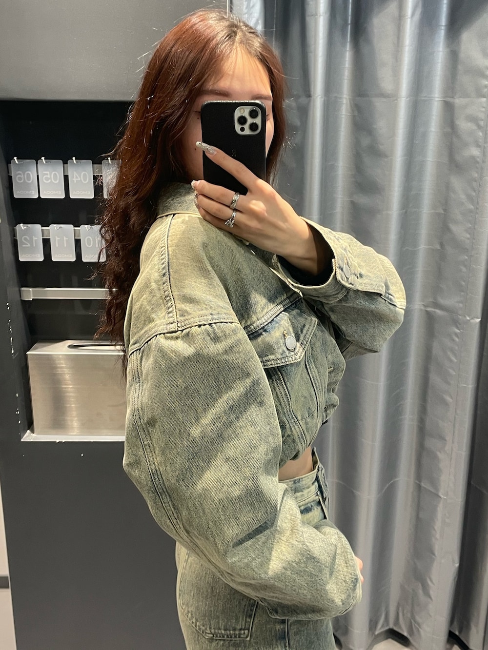 ブラック系のニット/セーター、ブルー系のデニムジャケット、ブルー系のデニムパンツを着用したレディースの冬コーディネートの5枚目の写真