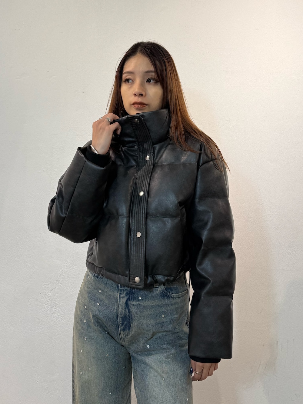 ブラック系のダウンジャケット/コート、ブルー系のデニムパンツ、ブラック系のブーツを着用したレディースの冬コーディネートの4枚目の写真