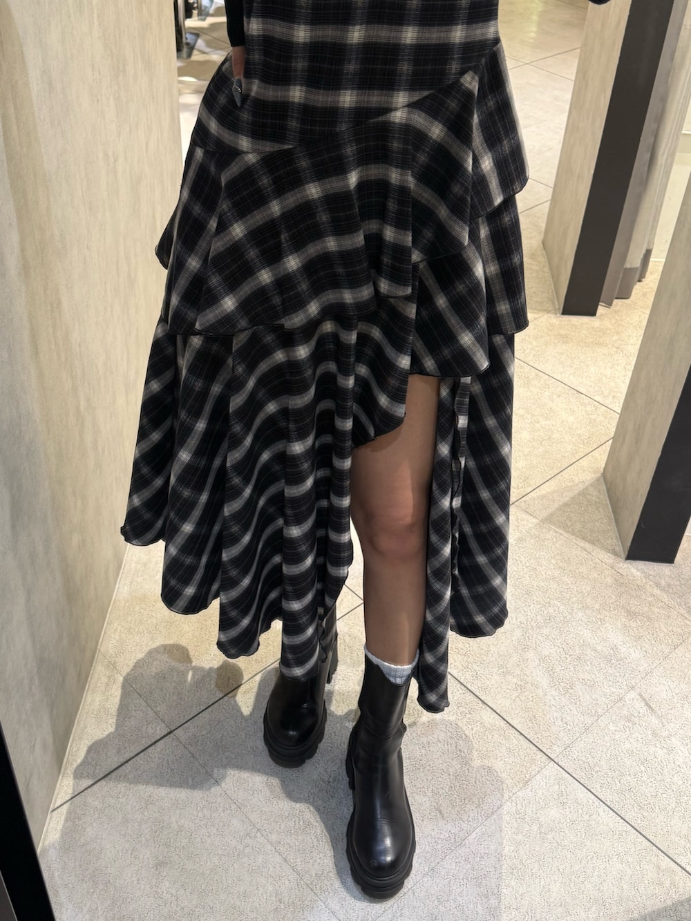 ブラック系のニット/セーター、ブラック系のワンピース、ブラック系のブーツを着用したレディースの春コーディネートの5枚目の写真