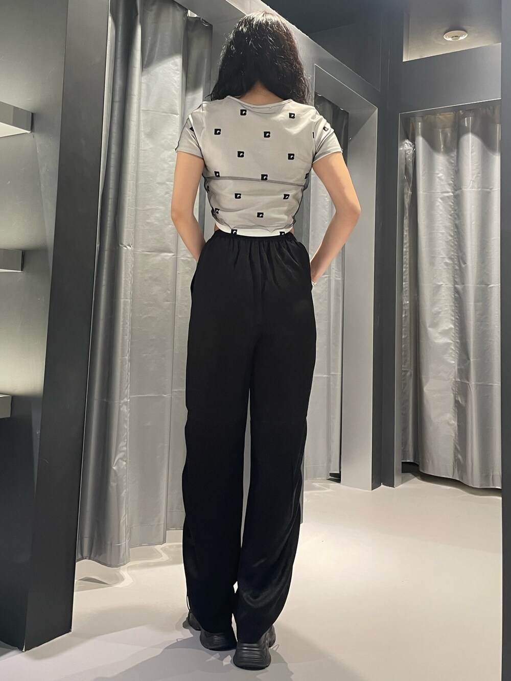 ホワイト系のTシャツ/カットソー、ブラック系のその他パンツ、ブラック系のサンダルを着用したレディースの春コーディネートの3枚目の写真