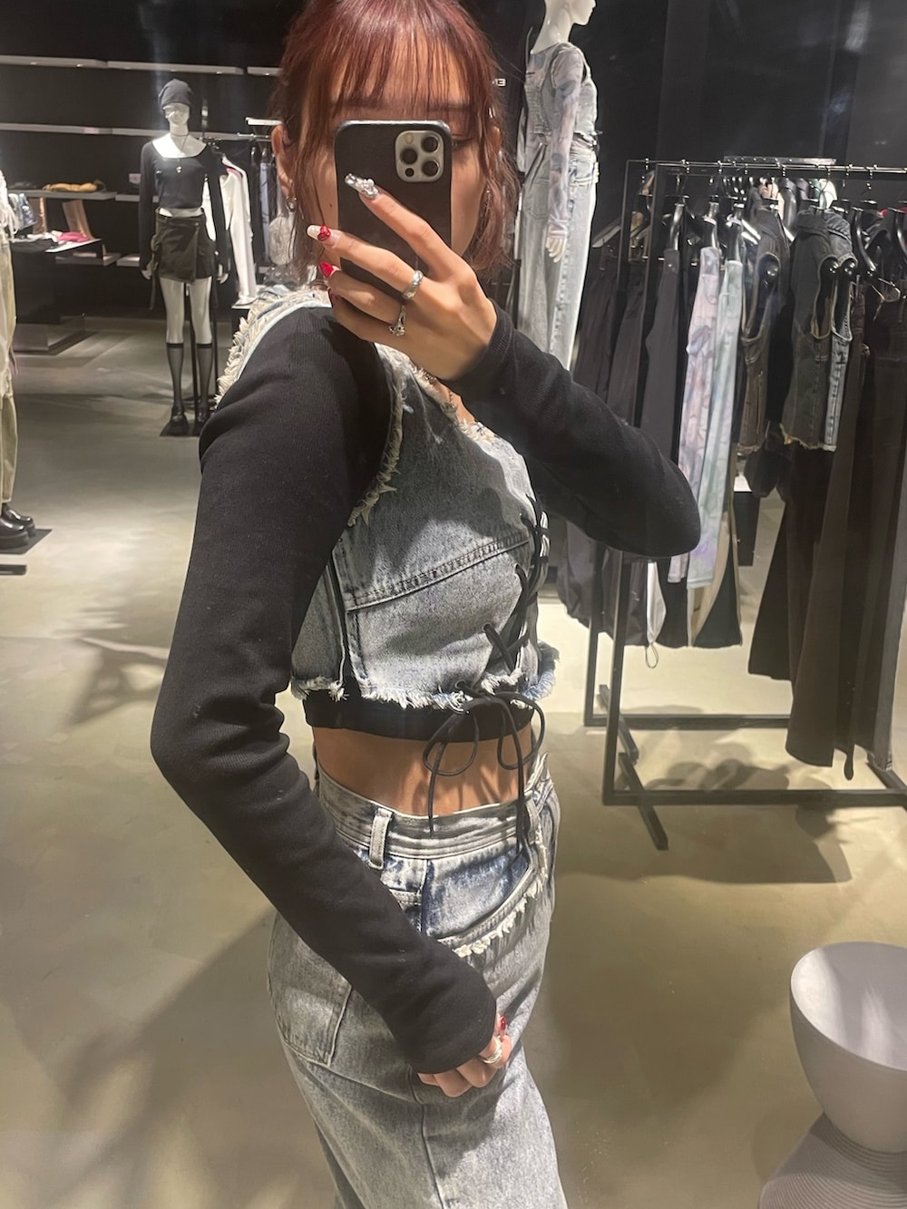 ブラック系のTシャツ/カットソー、ブルー系のデニムパンツ、ブラック系のブーツを着用したレディースの春コーディネートの5枚目の写真