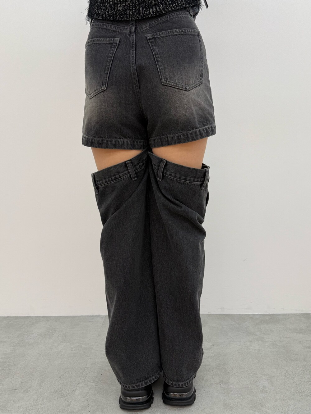 ブラック系のニット/セーター、ブラック系のデニムパンツ、ブラック系のハンドバッグを着用したレディースの夏コーディネートの9枚目の写真