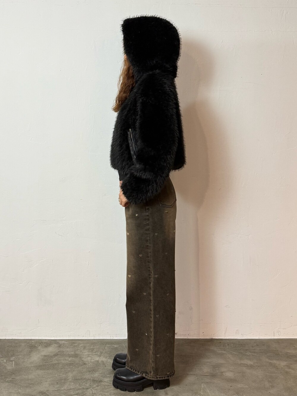 ブラック系のブルゾン、ブラウン系のデニムパンツ、ブラック系のブーツを着用したレディースの秋コーディネートの2枚目の写真