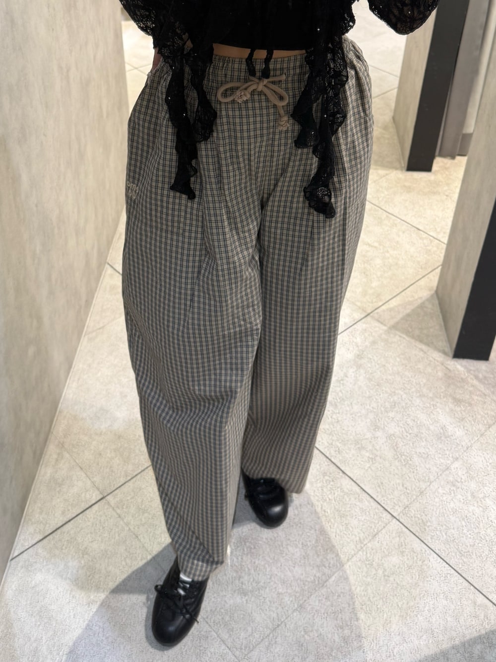 ブラック系のスニーカー、ベージュ系のその他パンツ、ブラック系のTシャツ/カットソーを着用したレディースの春コーディネートの5枚目の写真