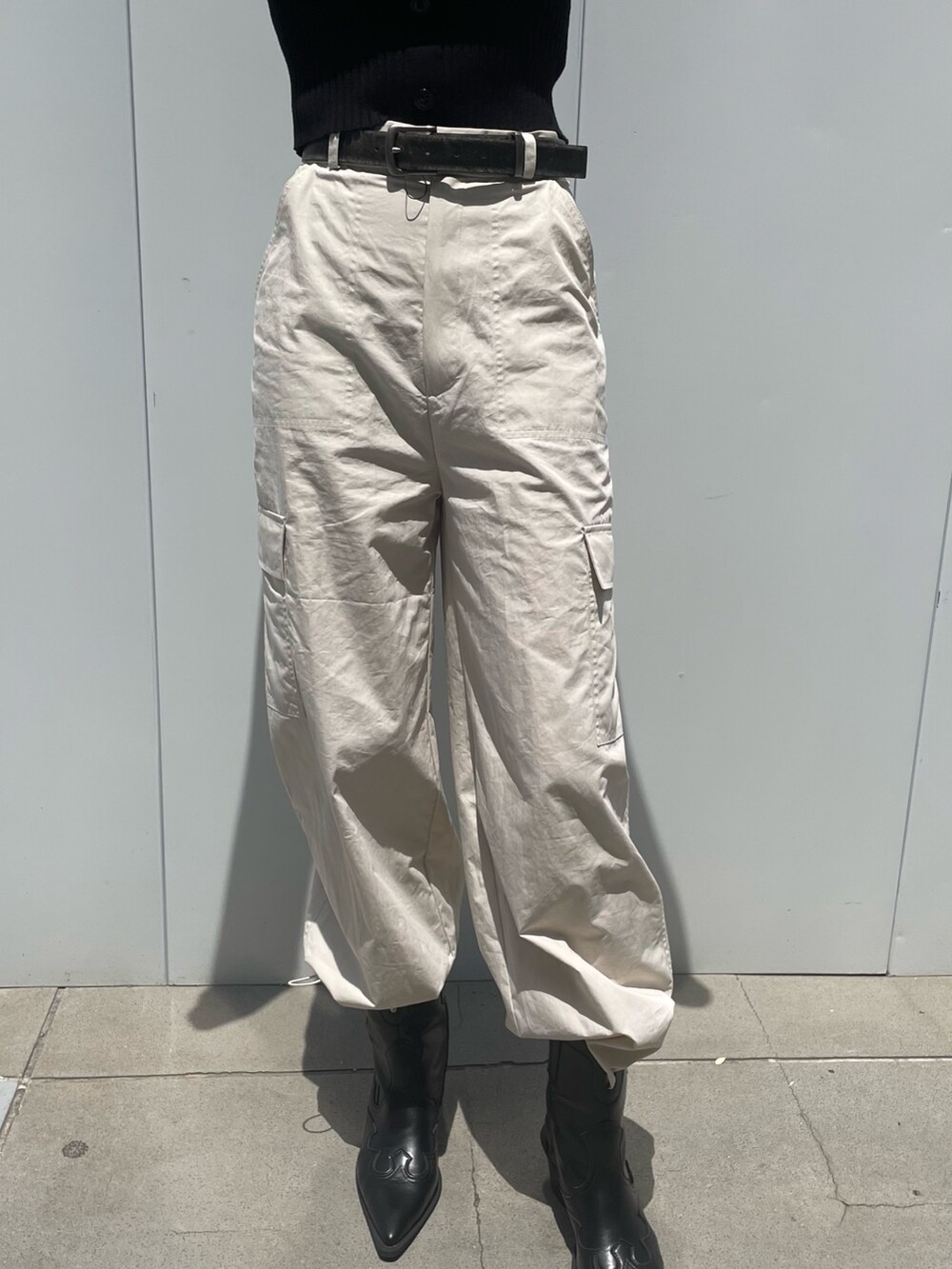 ホワイト系のカーゴパンツ、ブラック系のブーツ、ブラック系のベルトを着用したレディースの夏コーディネートの4枚目の写真