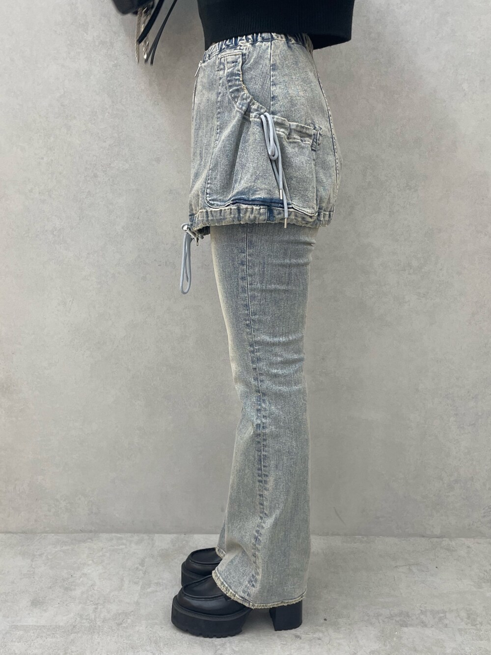 ホワイト系のニット/セーター、ブルー系のデニムパンツ、ブラック系のローファーを着用したレディースの夏コーディネートの7枚目の写真