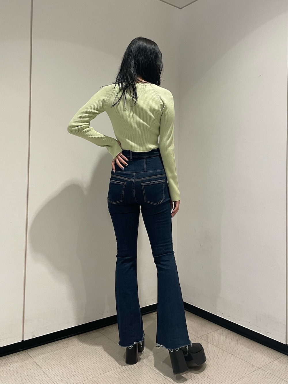 グリーン系のニット/セーター、ブルー系のデニムパンツ、ブラック系のブーツを着用したレディースの冬コーディネートの3枚目の写真