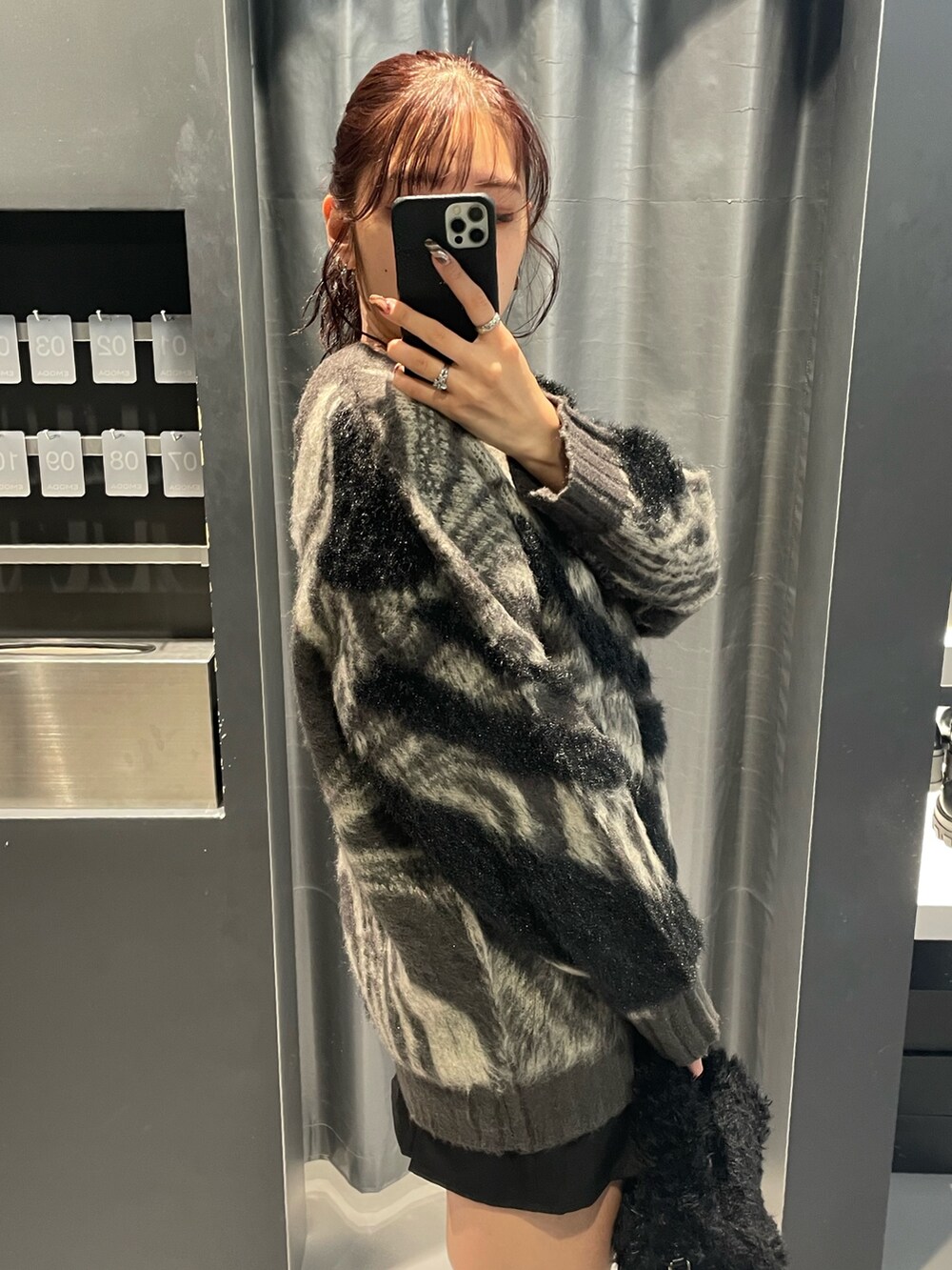 グレー系のニット/セーター、ブラック系のスカート、ブラック系のハンドバッグを着用したレディースの冬コーディネートの5枚目の写真