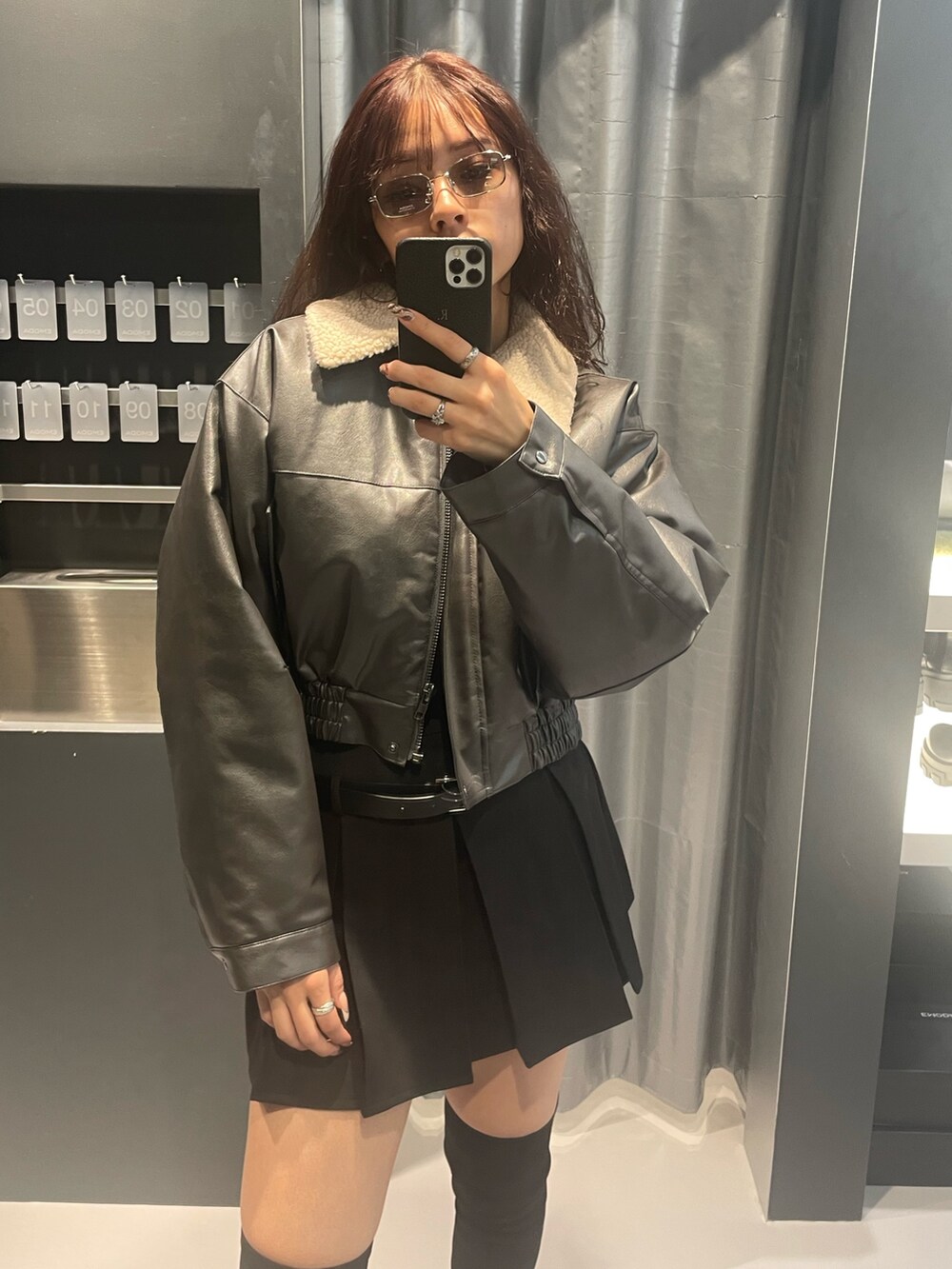 グレー系のブルゾン、ブラック系のTシャツ/カットソー、ブラック系のスカートを着用したレディースの冬コーディネートの4枚目の写真