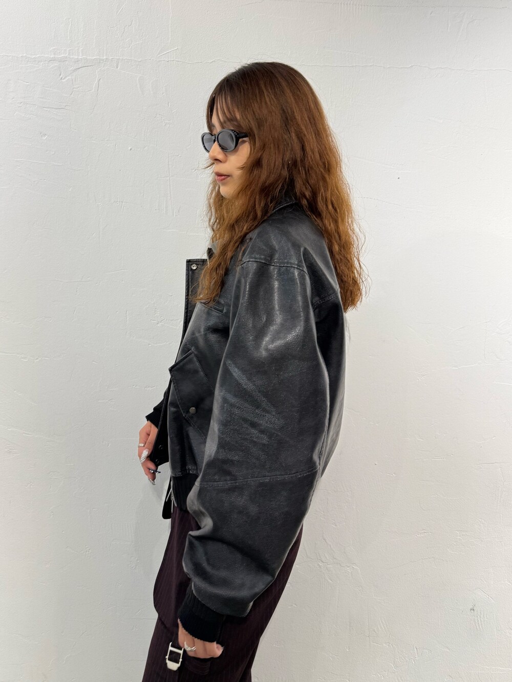 ブラック系のニット/セーター、ブラック系のブルゾン、ブラウン系のその他パンツを着用したレディースの秋コーディネートの5枚目の写真