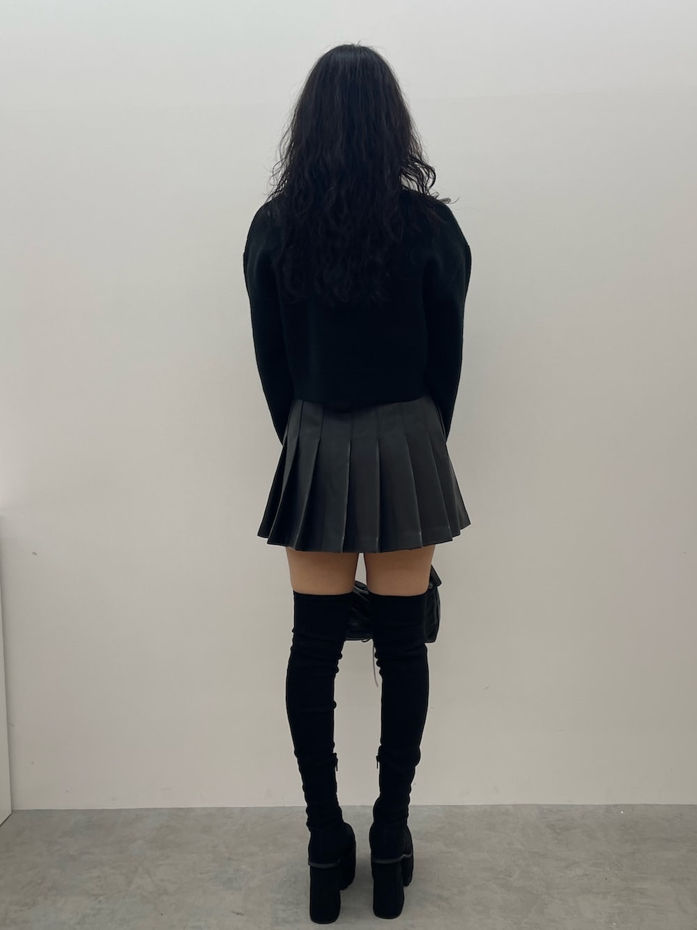 ブラック系のニット/セーター、グレー系のスカート、ブラック系のショルダーバッグを着用したレディースの夏コーディネートの3枚目の写真