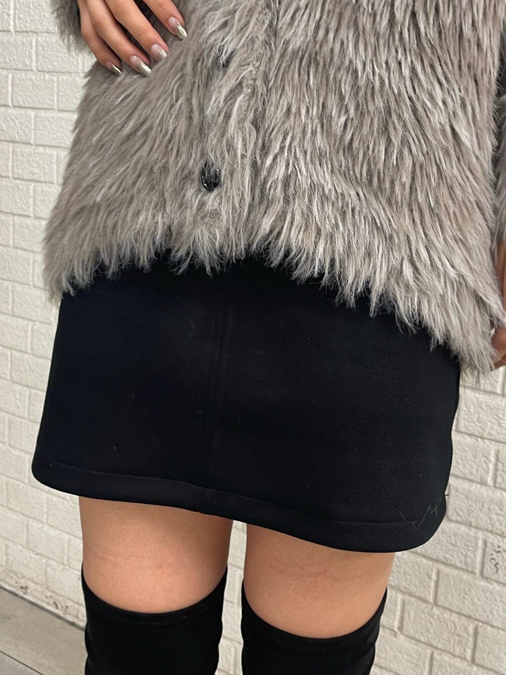 グレー系のカーディガン/ボレロ、ホワイト系のTシャツ/カットソー、ブラック系のスカートを着用したレディースの秋コーディネートの7枚目の写真