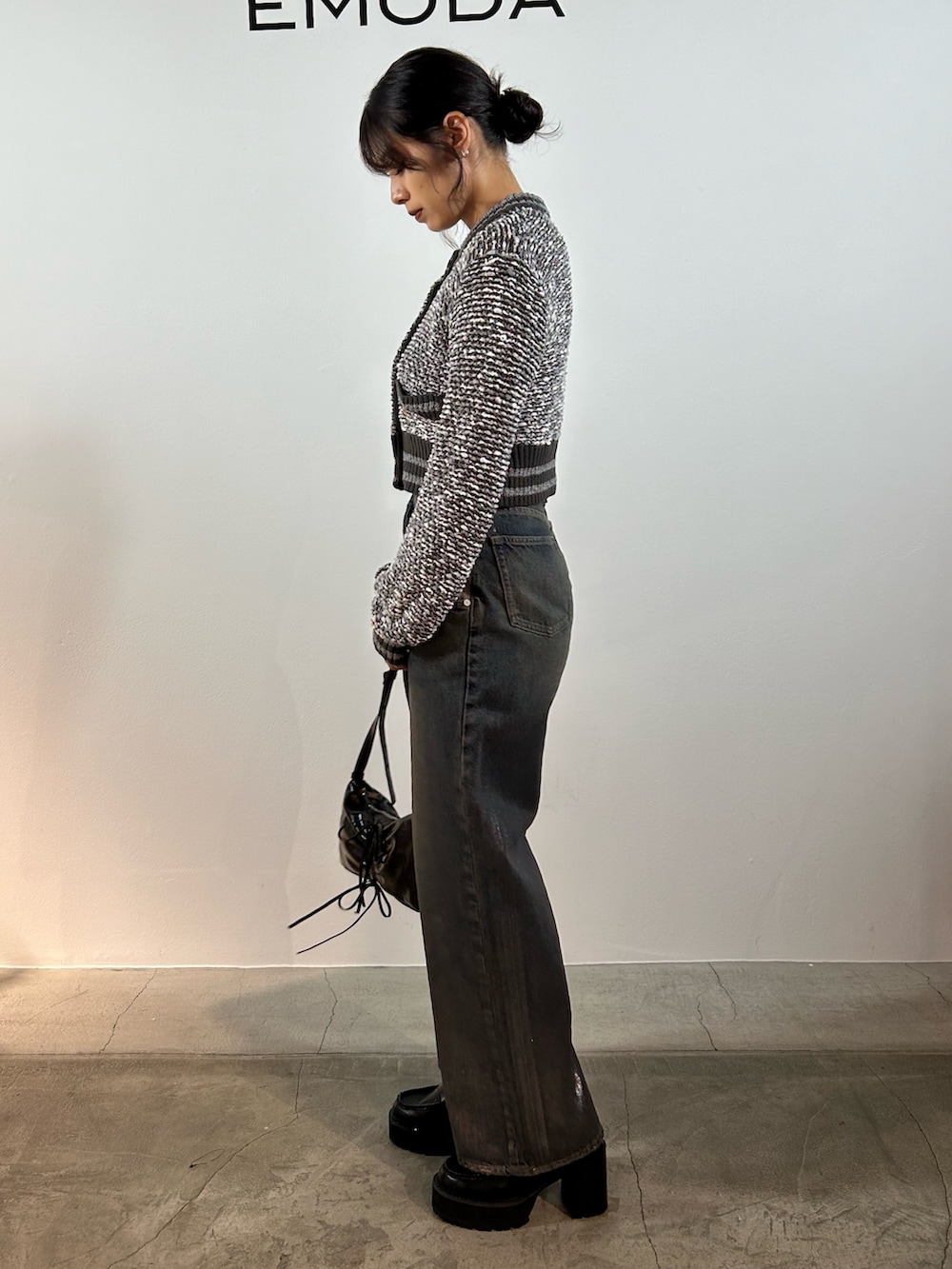 グレー系のカーディガン/ボレロ、ブルー系のデニムパンツ、ブラック系のショルダーバッグを着用したレディースの秋コーディネートの2枚目の写真