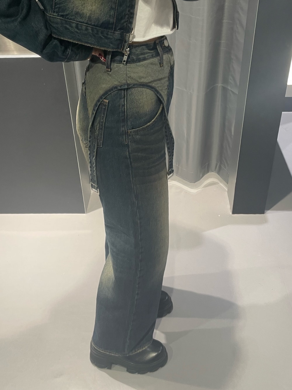 レッド系のニット/セーター、ブルー系のデニムパンツ、ブラック系のハンドバッグを着用したレディースの秋コーディネートの7枚目の写真