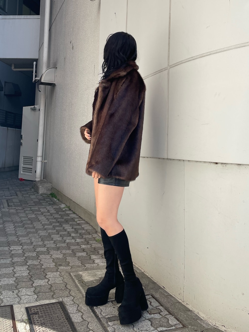 ブラック系のニット/セーター、ブラウン系のその他アウター、ブラック系のその他パンツを着用したレディースの冬コーディネートの2枚目の写真