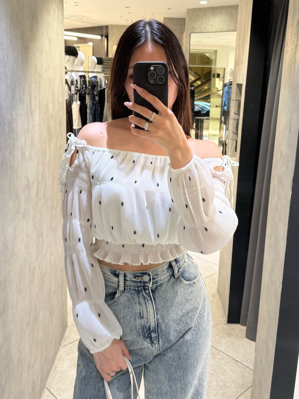 ホワイト系のTシャツ/カットソー、ブルー系のデニムパンツ、ホワイト系のショルダーバッグを着用したレディースの春コーディネートの4枚目の写真