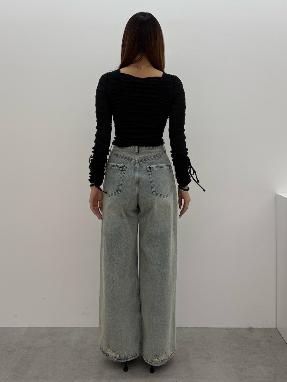 ブラック系のTシャツ/カットソー、ブルー系のデニムパンツ、ブラック系のスニーカーを着用したレディースの冬コーディネートの3枚目の写真