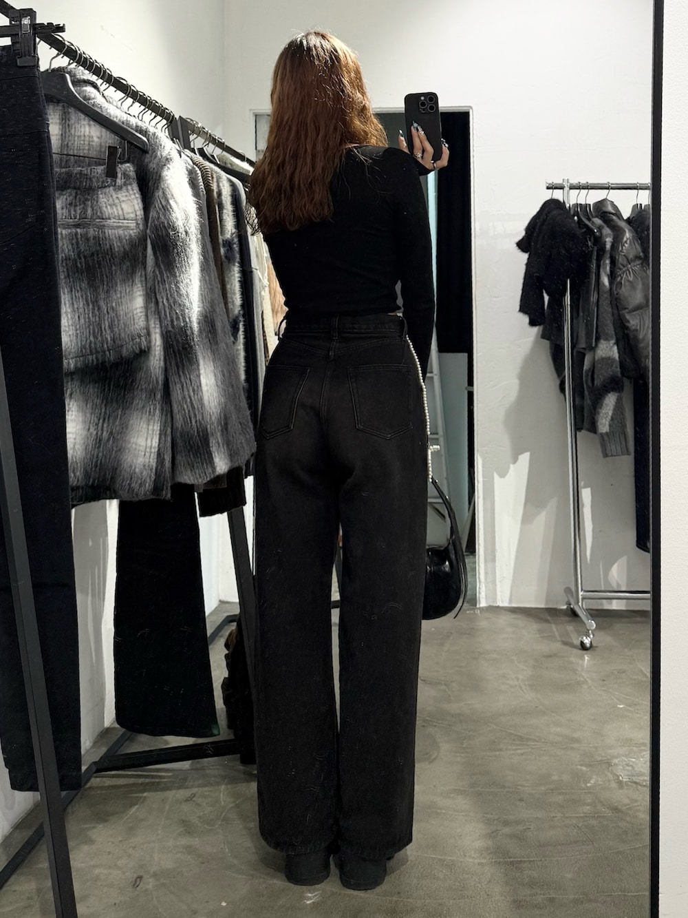 ブラック系のTシャツ/カットソー、ブラック系のデニムパンツ、ブラック系のショルダーバッグを着用したレディースの秋コーディネートの3枚目の写真