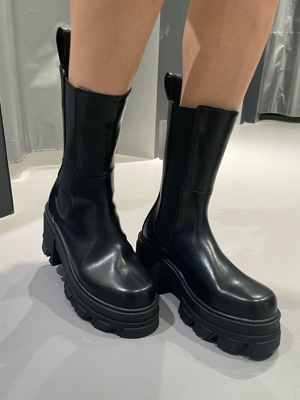 ブラック系のワンピース、ブラック系のデニムパンツ、ブラック系のブーツを着用したレディースの秋コーディネートの9枚目の写真