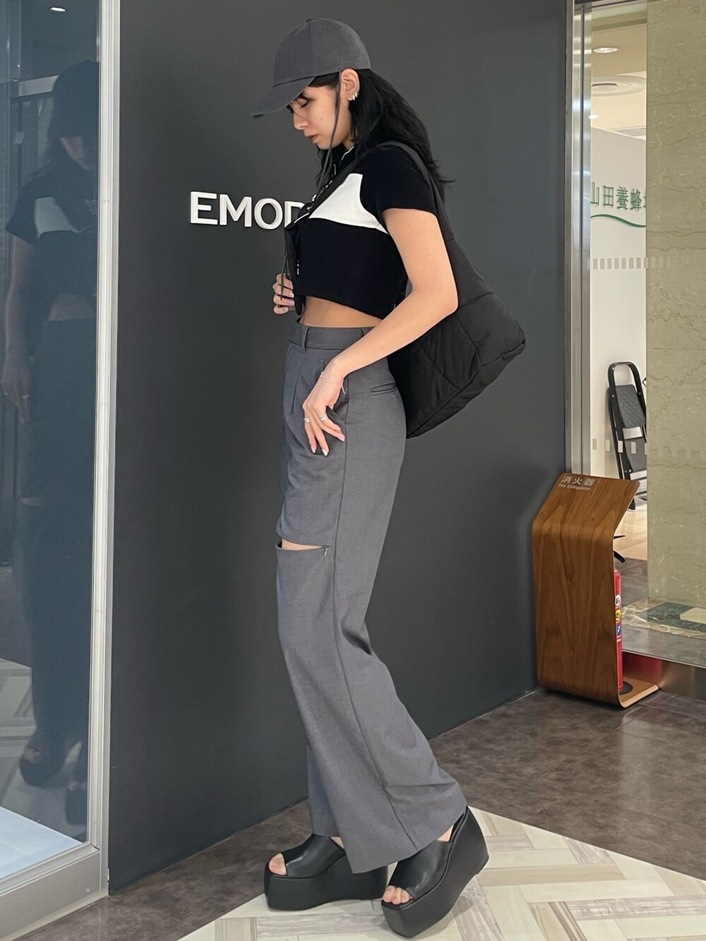 ブラック系のTシャツ/カットソー、グレー系のその他パンツ、ブラック系のサンダルを着用したレディースの春コーディネートの2枚目の写真