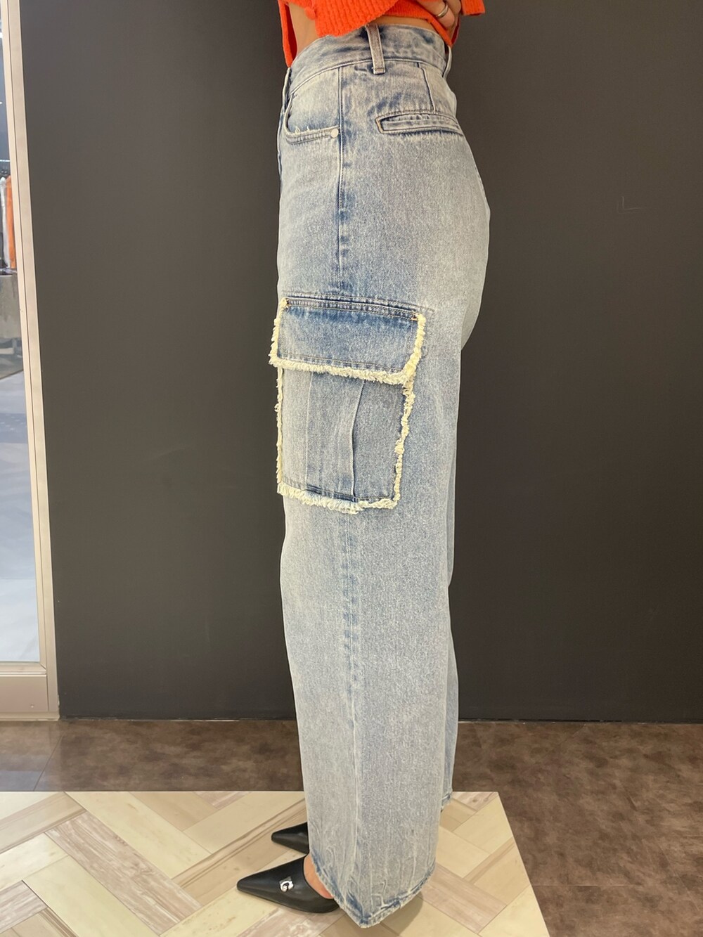 オレンジ系のニット/セーター、ブルー系のデニムパンツ、ブラック系のパンプスを着用したレディースの春コーディネートの8枚目の写真