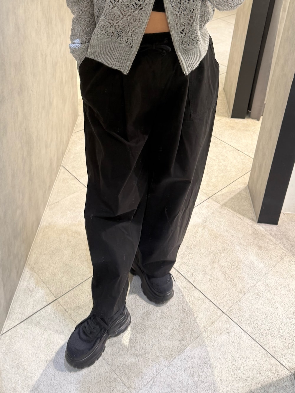 グレー系のパーカー、ブラック系のその他パンツ、ブラック系のスニーカーを着用したレディースの春コーディネートの5枚目の写真