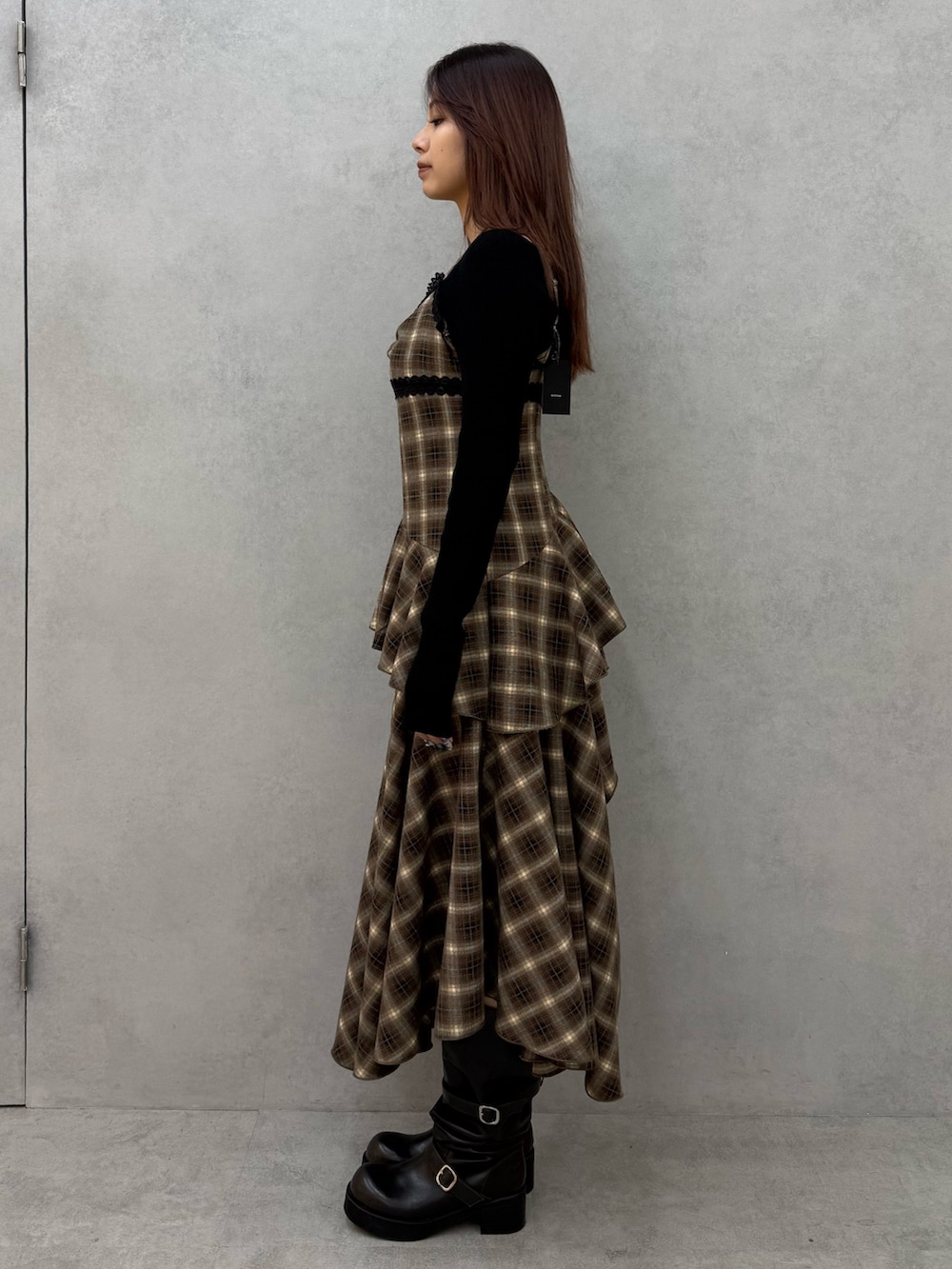 ブラック系のニット/セーター、ベージュ系のワンピース、ブラック系のブーツを着用したレディースの冬コーディネートの2枚目の写真