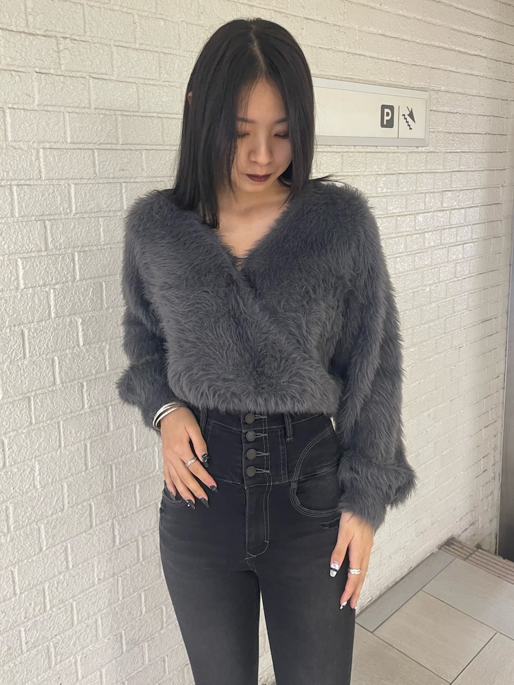 グレー系のニット/セーター、ブラック系のデニムパンツ、ブラック系のブーツを着用したレディースの冬コーディネートの4枚目の写真