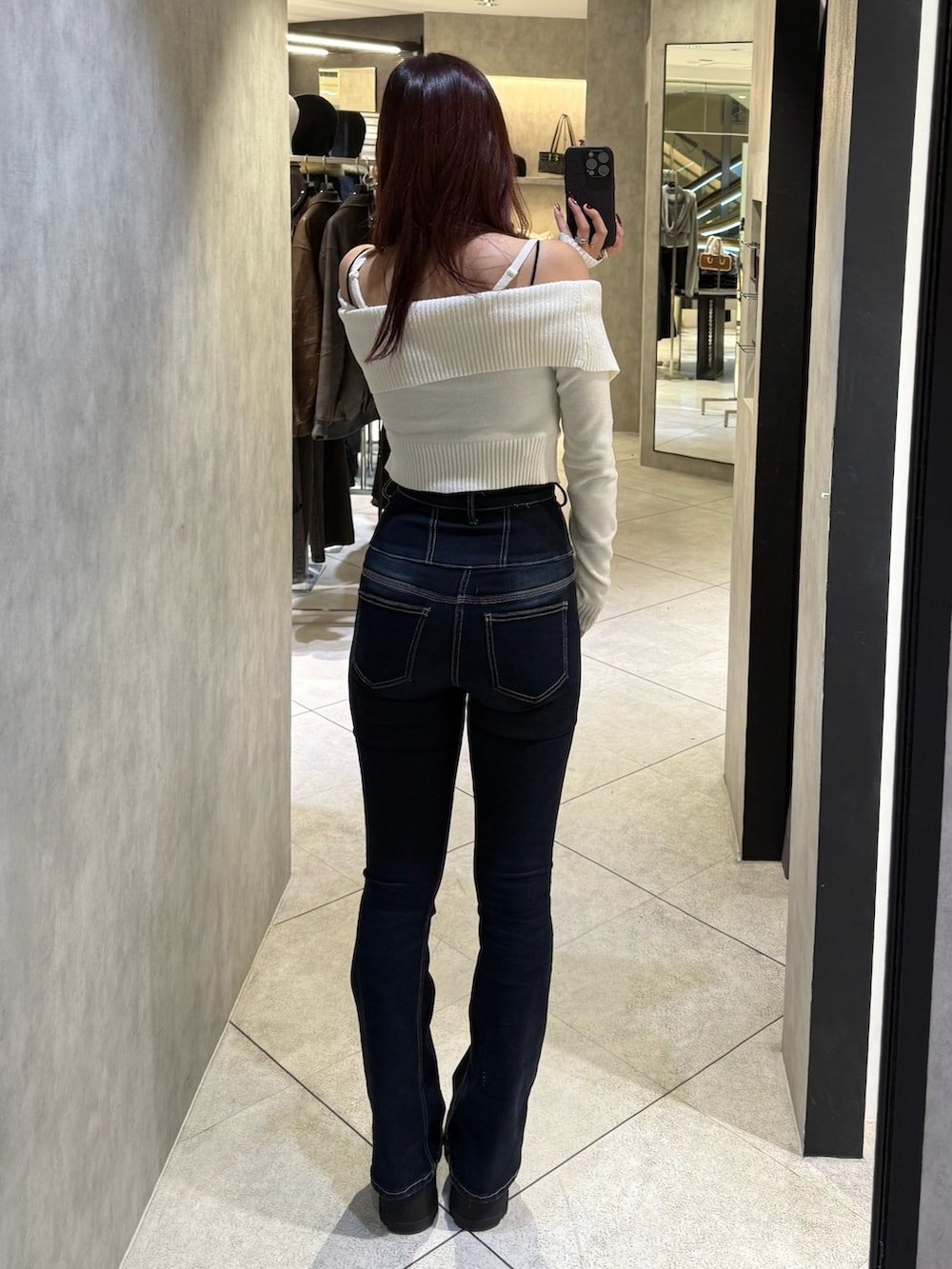 ホワイト系のニット/セーター、ブルー系のデニムパンツ、ブラック系のブーツを着用したレディースの秋コーディネートの3枚目の写真