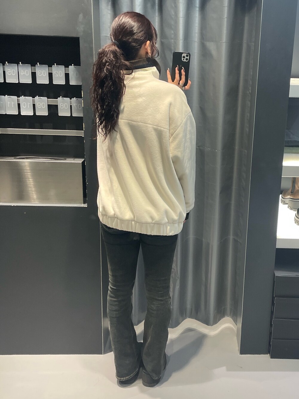 ホワイト系のブルゾン、ブルー系のハンドバッグ、ブラック系のデニムパンツを着用したレディースの秋コーディネートの3枚目の写真