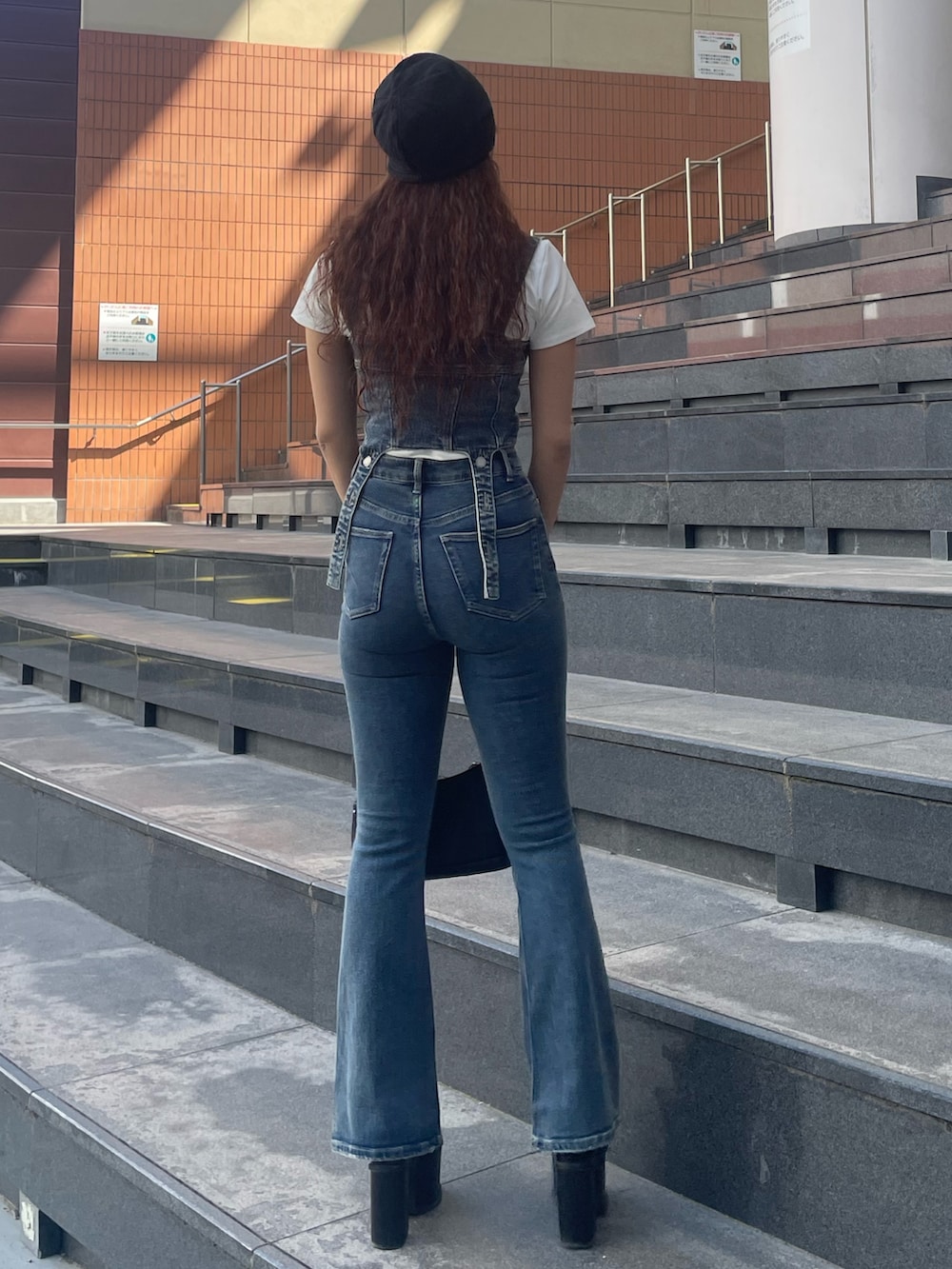 ホワイト系のTシャツ/カットソー、ブルー系のサロペット/オーバーオール、ブラック系のハンドバッグを着用したレディースの春コーディネートの3枚目の写真