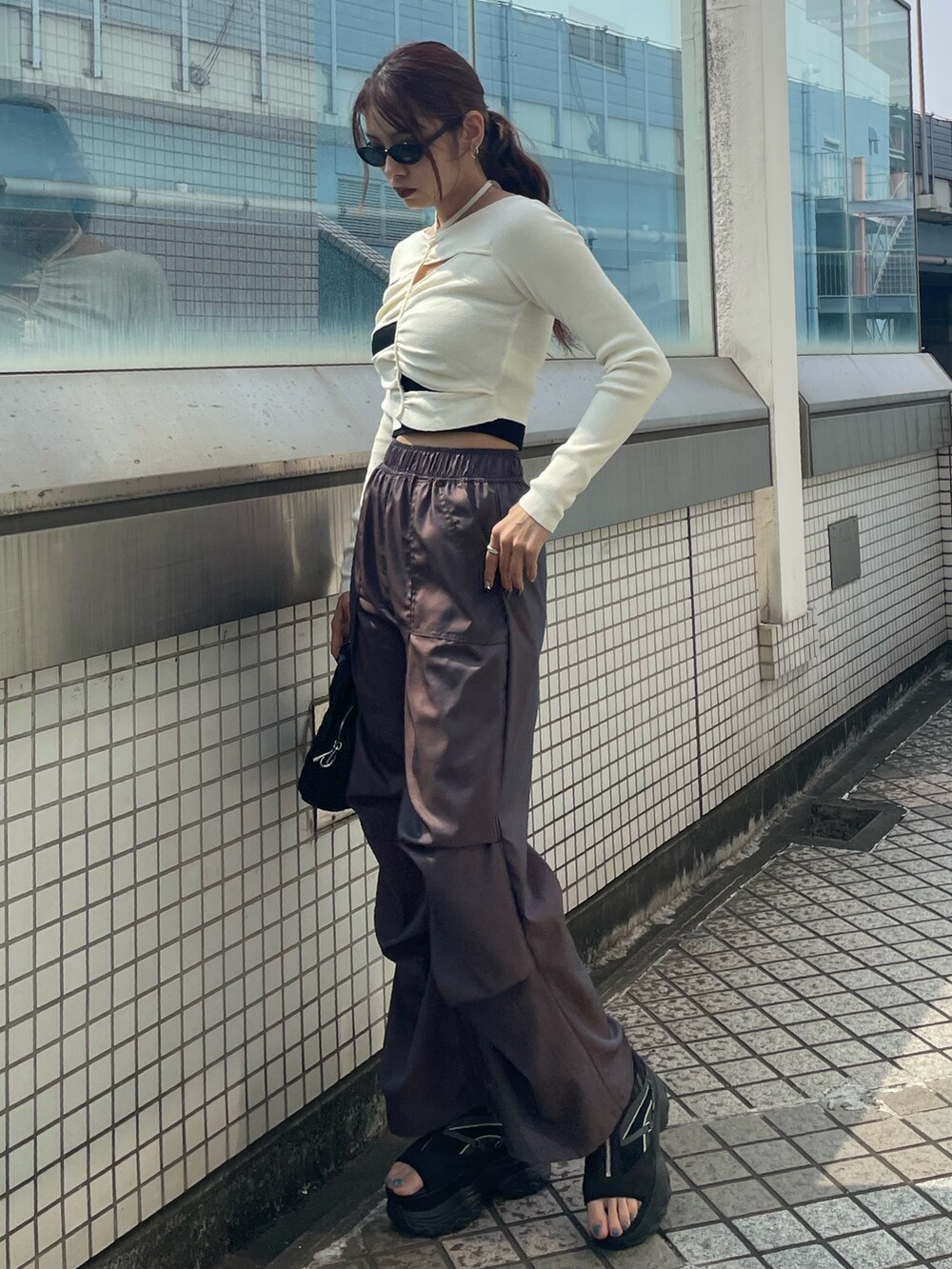 ホワイト系のニット/セーター、ブラック系のTシャツ/カットソー、ブラウン系のその他パンツを着用したレディースの春コーディネートの2枚目の写真