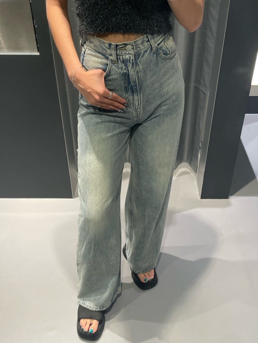 ホワイト系のTシャツ/カットソー、ブルー系のデニムパンツ、ブラック系のハンドバッグを着用したレディースの秋コーディネートの6枚目の写真