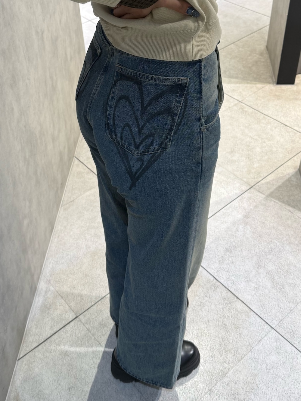 ベージュ系のシャツ/ブラウス、ブルー系のデニムパンツ、ブラック系のブーツを着用したレディースの冬コーディネートの6枚目の写真