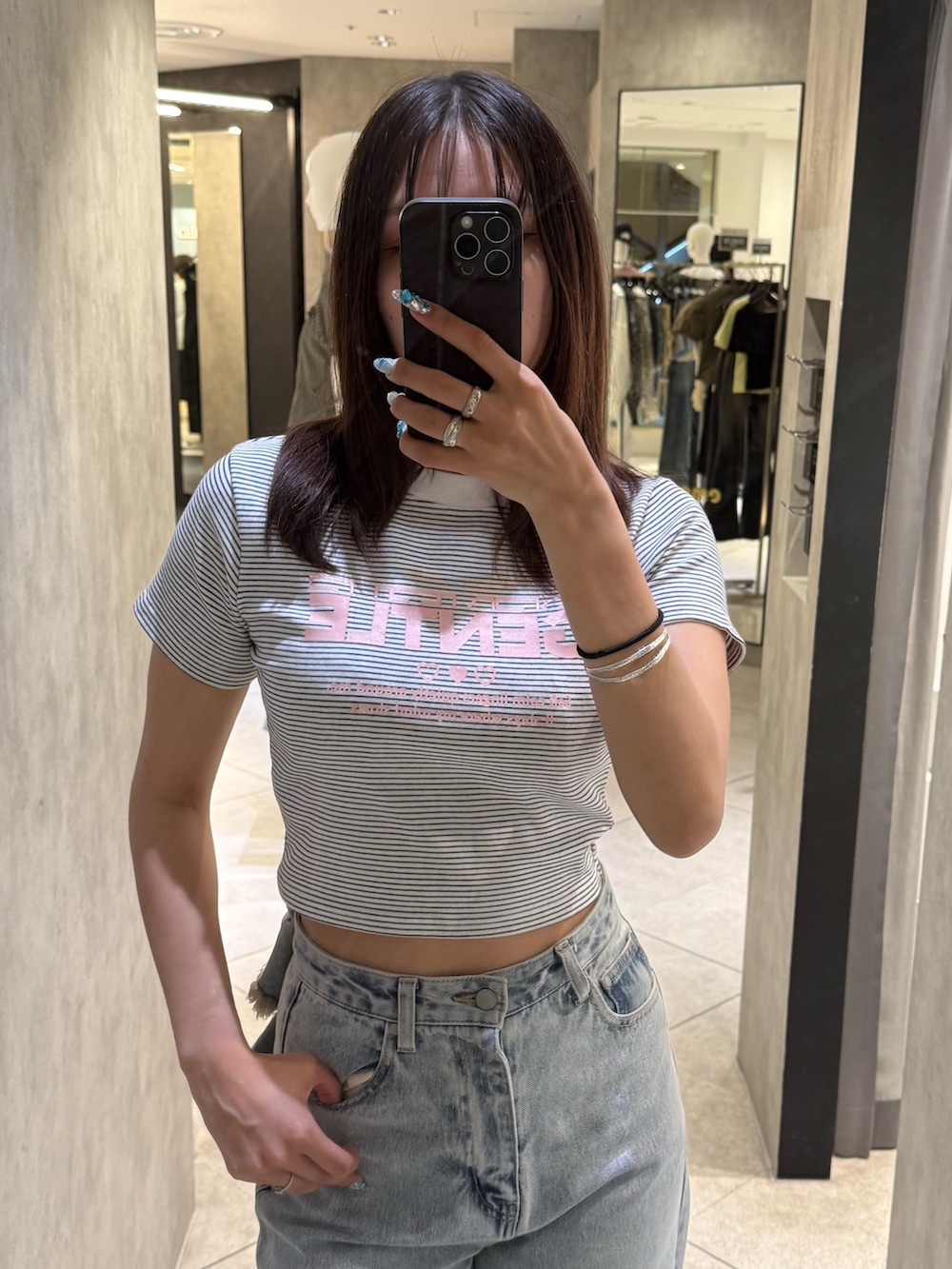 ホワイト系のTシャツ/カットソー、ブルー系のデニムパンツ、ブラック系のスニーカーを着用したレディースの春コーディネートの4枚目の写真