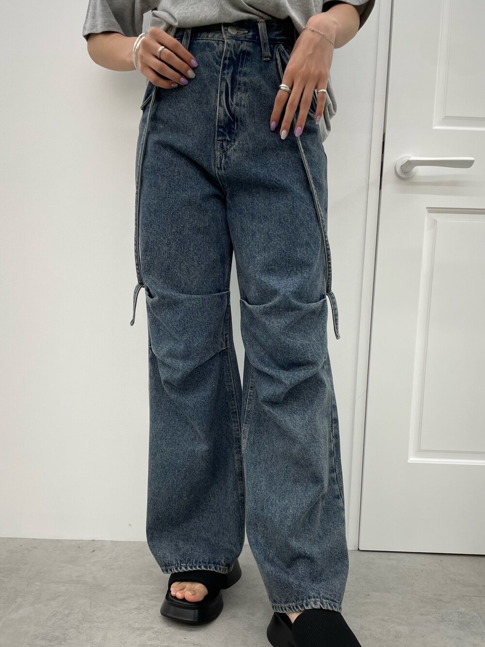 グレー系のTシャツ/カットソー、ブルー系のデニムパンツ、ブラック系のサンダルを着用したレディースの春コーディネートの5枚目の写真